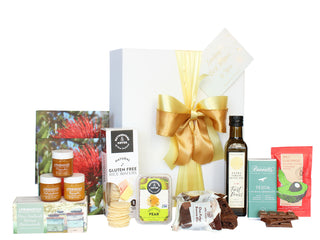 Gift Box Image Large luxury white gift box with gold ribbon and a card, packed with napkins, three pots of 40 gram honey, Rutherford and Meyer crackers, fruit paste and gourmet dip mix, 250ml bottle of extra virgin olive oill, Mrs Higgin's chocolate fudge brownie and Bennett's of Mangawhai Chocolate bar Batenburgs Gift Baskets Auckland