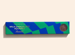 Box of milk chocolate squares with a green and blue design on a beige background