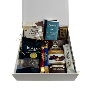 Gift Box Image Medium glossy white gift box with Mrs Higgin's chocolate cookie, chocolate covered almonds, two Whittakers chocolate bars, Whittaker peanut slab, espresso chocolate bar, two bennetts chocolate bars and chocolate covered hokey pokey, shot from above, Batenburgs Gift Baskets Auckland