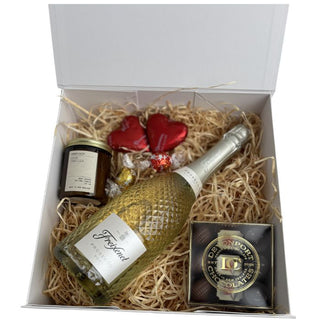 Gift Box Image Medium white gift box, Freixenet prosecco, Lindt lindor chocolates, chocolate hearts, amberjack candle, davenport chocolates. Shot from above. Batenburgs Gift Baskets Auckland