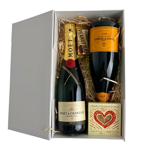 Gift Box Image Large white deluxe gift box with Moët and Chandon Imperial Champagne, Veuve Clicquot Brut Yellow label both 750ml, Russian fudge and a peanut slab. shot from above. Batenburgs Gift Baskets Auckland 