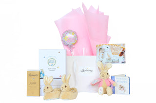 Gift Box Image White gift bag with pink Vilene, Peter Rabbit boots, Flopsy Bunny soft toy, Peter rabbit book, It's a girl balloon mini and Bennett's of Mangawhai chocolate Gift Baskets Auckland