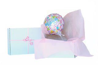 Pink balloon that says it's a baby girl, in a white box with pink Vilene