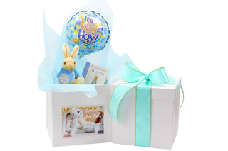 White gift box with it's a boy blue balloon, Peter Rabbit soft toy and Peter Rabbit book